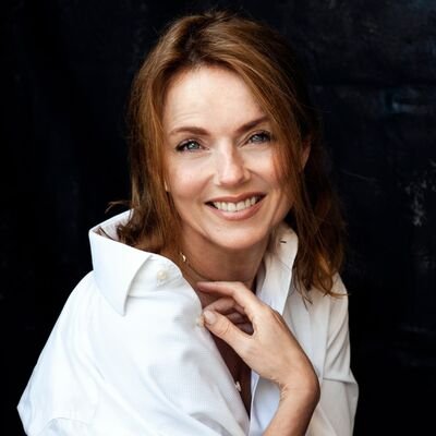 Geri Halliwell smiling at an event, wearing elegant attire.