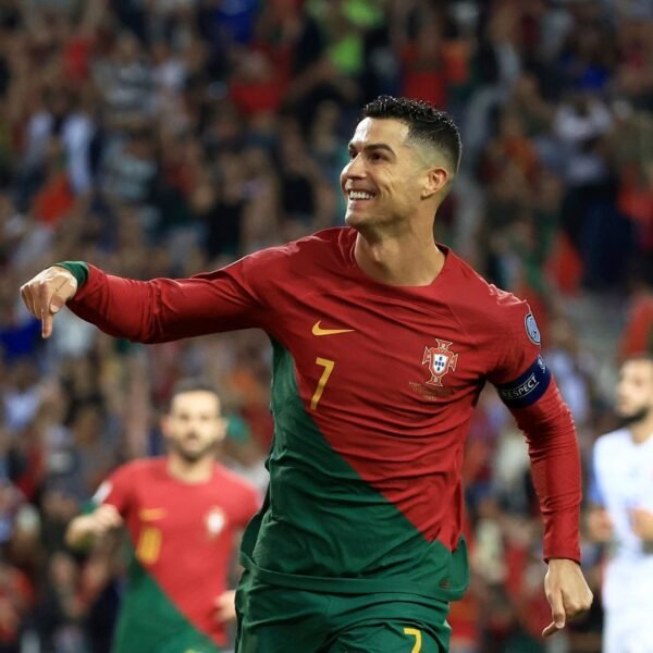 Cristiano Ronaldo in suit smiling, symbolizing his $500 million net worth in 2025