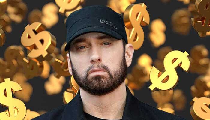 Eminem performing on stage in a hoodie, representing his success and net worth in 2025