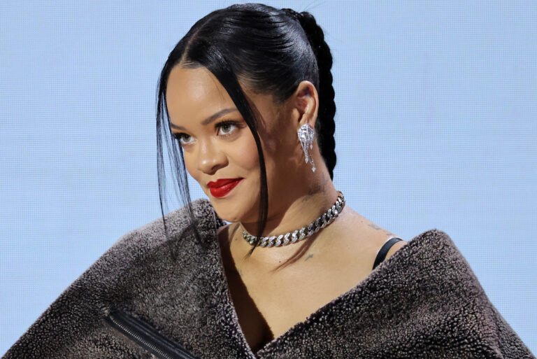 Rihanna smiling in a stylish outfit, symbolizing her $1.7 billion net worth in 2025 from music, Fenty Beauty, and fashion ventures.