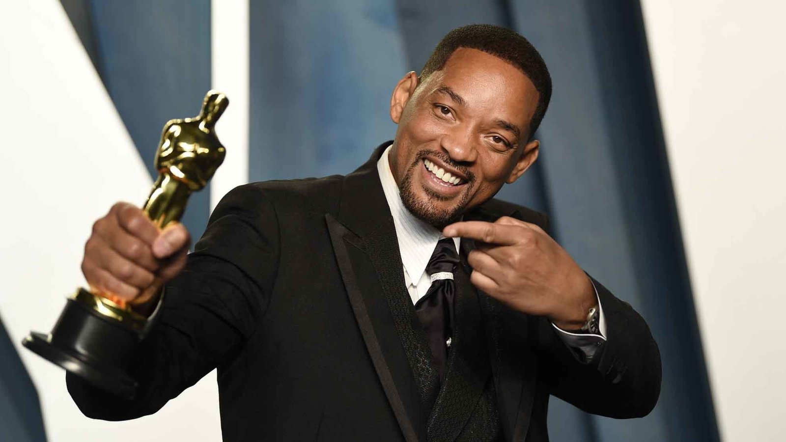 Will Smith smiling in a suit at a red carpet event – Will Smith Net Worth 2025